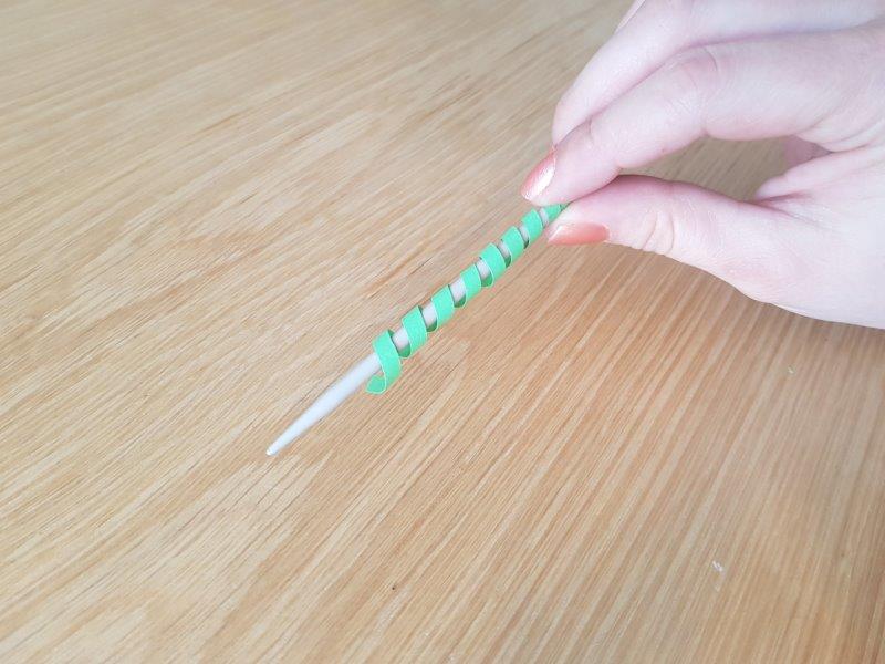 Hele strimmel rullet omkring strikkepind. Instruks 4.